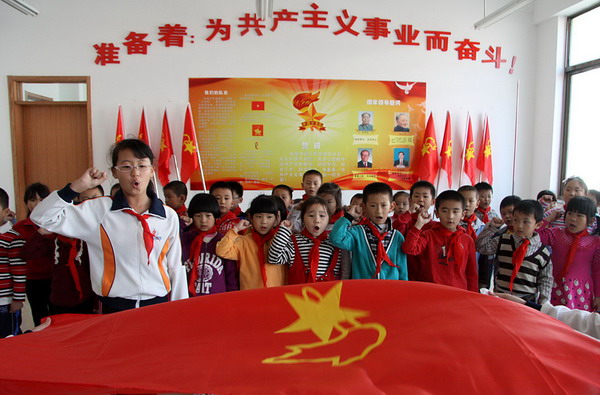 New league members take an oath to the flag in the anniversary ceremony in Weihai, Shandong province, Oct 12, 2010. [Xinhua] 