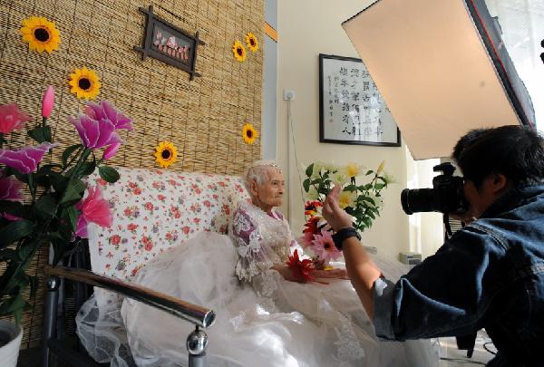 Chen Laikang, who is 101 years old, poses for photos in a suit of wedding dress in Tianjin, north China, Oct. 13, 2010. Chen realized her dream of taking pictures in wedding dress as the Double Ninth Festival draws on. The festival is also known as &apos;Chongyang Festival&apos; or &apos;Old Veneration Festival&apos;, a Chinese traditional occasion to pay respect to the aged. [Xinhua] 