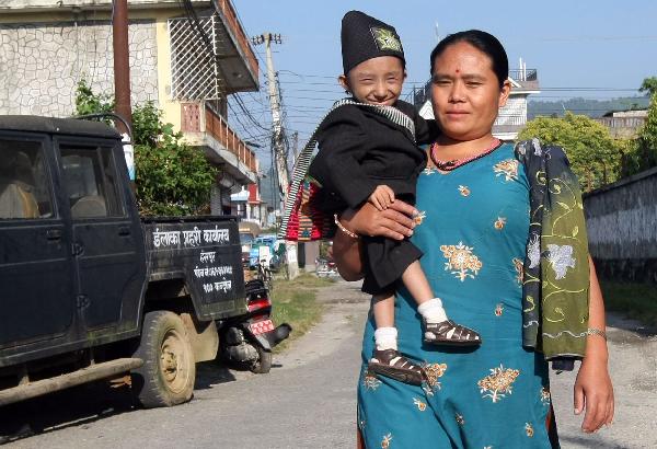 Khagendra Thapa&apos;s mother holds him in her arm. They&apos;re on the way to a local hospital in Pokhara West Nepal October 13, 2010. [Xinhua/AFP]