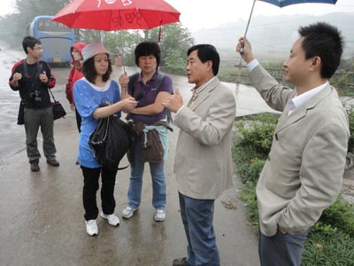 Tourism director for the Feng Huan Village talks to reporters from China Radio International on October 12, 2010. [Photo:CRIENGLISH.com]