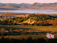 Photo shows the fascinating scenery of Saihanba National Forest Park in Chengde, north China's Hebei Province. The park used to be part of the 'royal hunting ground' in Qing Dynasty. People can find the vast sea of cloud, the immense meadow, the limpid plateau lake and the historical relics of Qing dynasty in this 410,000 mu (about 273 square kilometers) forest park. [Photo by Jia Yunlong]