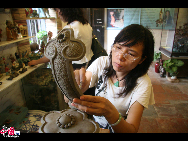 A woman is working on her ceramic handicraft in her shop in Foshan, south China's Guangdong Province. [Jessica Zhang/China.org.cn]