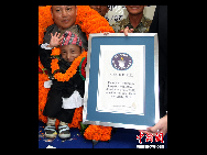 Khagendra Thapa waves after receiving the certificate from Marco Frigatti, Vice-President of   Guinness Book of World Records, at a function in Pokhara, west of Kathmandu October 14, 2010. [Chinanews.com]