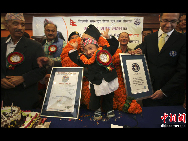 Khagendra Thapa waves after receiving the certificate from Marco Frigatti, Vice-President of   Guinness Book of World Records, at a function in Pokhara, west of Kathmandu October 14, 2010. [Chinanews.com]