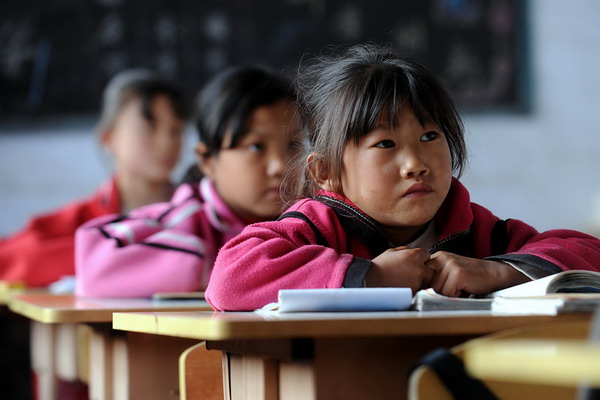 Seven-year-old Wang Yanfang (right) pays attention during class at Xichan School in Changzhi, Shanxi province, Oct 14, 2010. [Xinhua]