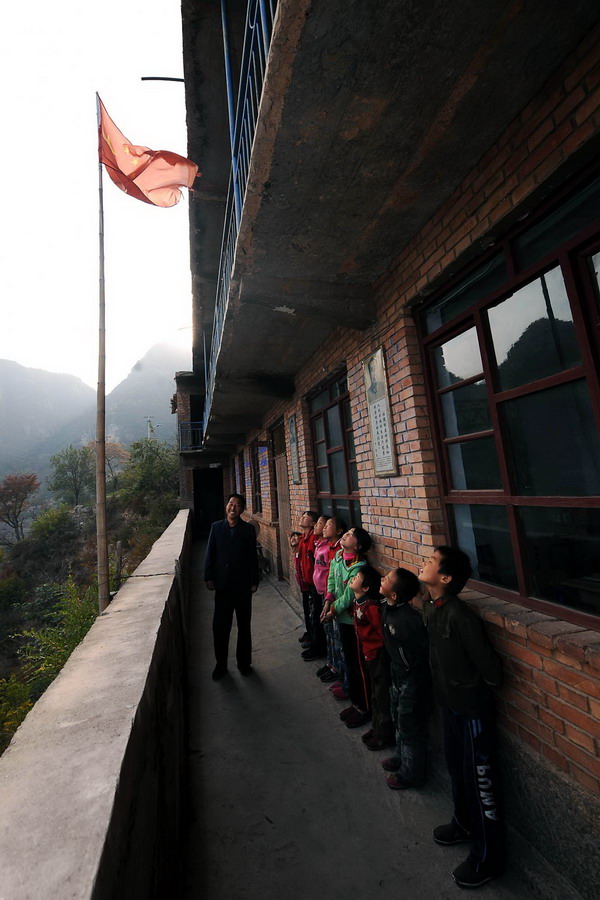 Yuan Zichao tells students about the national flag at Xichan School in Changzhi, Shanxi province, Oct 14, 2010. [Xinhua] 