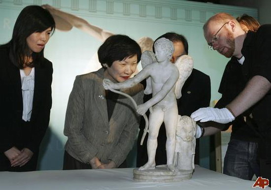 Chou Kung-shin (2nd from left), director of Taiwan&apos;s Palace Museum, looks at a marble statue of Eros as the staff of British Museum move it during a media event announcing the exhibition of &apos;The Body Beautiful in Ancient Greece&apos;, in Taipei on Oct 5, 2010. [China Daily/Agencies] 