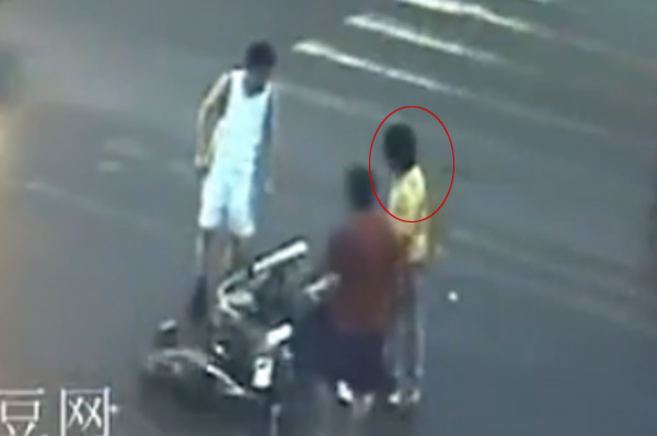 Two passers-by talk with the man whose motorbike crashed into a light truck on a street in Wenzhou, East China&apos;s Zhejiang province, June 21, 2010. [Photo/Video grab from tudou.com]