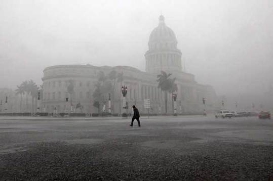 A man crosses the street near the Capitol building during thunderstorms in Havana October 14, 2010. The rains of tropical storm Paula began affecting Cuba since early Thursday morning, mainly in Pinar del Rio province in the west of the island state, according to the National Institute Meteorology (INSMET). [Xinhua/Reuters] 