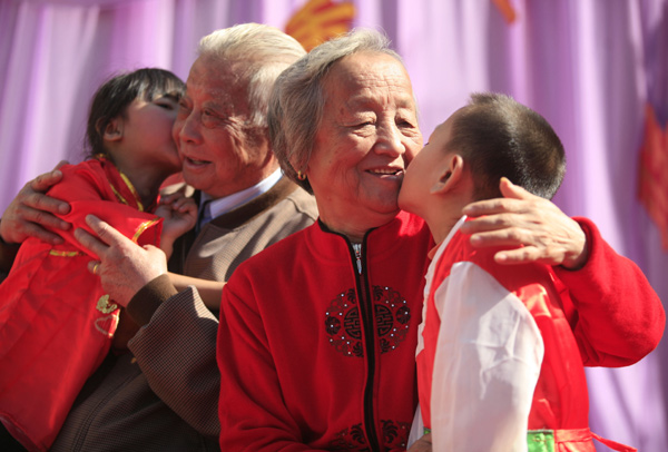 Children kiss an elderly couple celebrating their 50th wedding anniversary in Tianjin on Friday, a day before the traditional Chongyang Festival, a time to show respect to the elderly. [Wang Huan/China Daily]