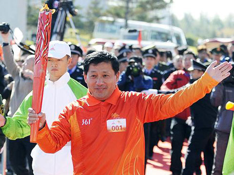 Xin Qingshan, China's famous speed skating coach, runs the first section in the torch relay on Friday, October 15, 2010. [Xinhua]