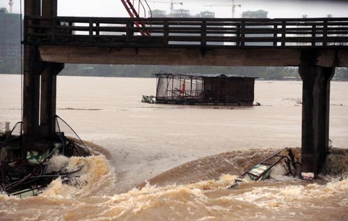 Floating fish enclosures are flushed away by flood water in the Wanquan River in Qionghai, South China's Hainan province, Oct 16, 2010. [Xinhua]