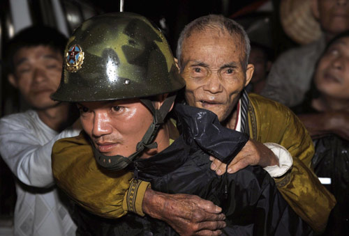 A rescuer helps evacuate a local resident in Wancheng county, the worst-hit county in Wanning city, South China's Hainan province, Oct 16, 2010. [Xinhua]