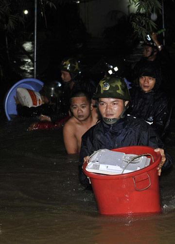 A rescuer helps evacuate belongings of local residents in Wancheng county, the worst-hit county in Wanning city, South China's Hainan province, Oct 16, 2010. [Xinhua]