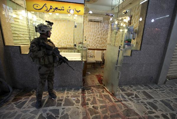 An Iraqi soldier stands guard near a goldsmith's shop after an attack during a robbery in Baghdad October 17, 2010. At least 12 people died when gunmen swooped down on a row of goldsmiths' shops in a brazen midday robbery in the Iraqi capital on Sunday and ended up in a gunfight with security forces, police and military sources said. [Xinhua]