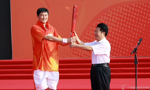 Torchbearer Du Feng receives 'The Tide'. Torch Relay for the 16th Asian Games continues in Dongguan, South China's Guangdong Province, Oct. 17, 2010. [GAGOC]