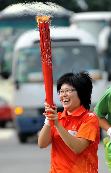 Torchbearer Liu Zhuojun runs with the torch during the Torch Relay for the 16th Asian Games in Dongguan
