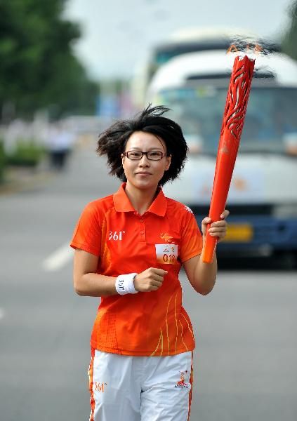 Torchbearer Yang Jie runs with the torch during the Torch Relay for the 16th Asian Games in Dongguan, South China's Guangdong Province, Oct. 17, 2010. (Xinhua/Liu Dawei) 