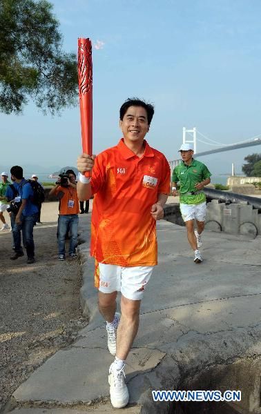 Torchbearer Wang Yuping runs with the torch during the Torch Relay for the 16th Asian Games in Dongguan, South China's Guangdong Province, Oct. 17, 2010. (Xinhua/Liu Dawei) 