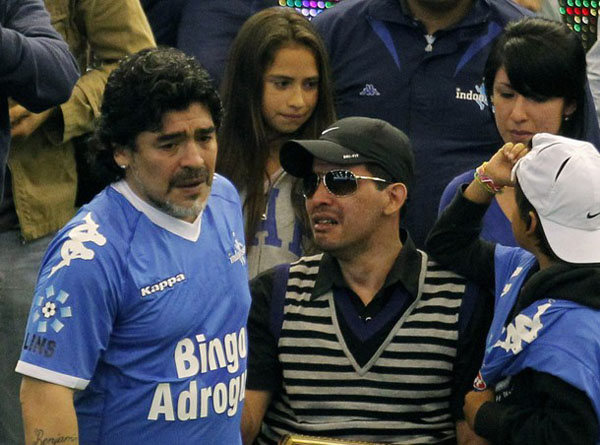 Former Argentina's national soccer team coach Diego Maradona (L) greets ex-soccer player Fernando Caceres before a charity match in Buenos Aires, October 16, 2010. Caceres, was shot in his head through his car's windshield during a robbery attempt on November 1, 2009. (Xinhua/Reuters Photo)