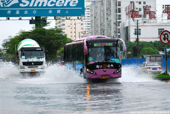 Vehicles wade through on waterlogged street in Haikou, capital of south China's Hainan Province, Oct. 17, 2010. The heavy rainfall in the city on Sunday caused severe waterlogging in some areas.