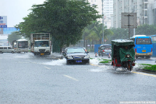 Vehicles wade through on waterlogged street in Haikou, capital of south China's Hainan Province, Oct. 17, 2010. The heavy rainfall in the city on Sunday caused severe waterlogging in some areas.