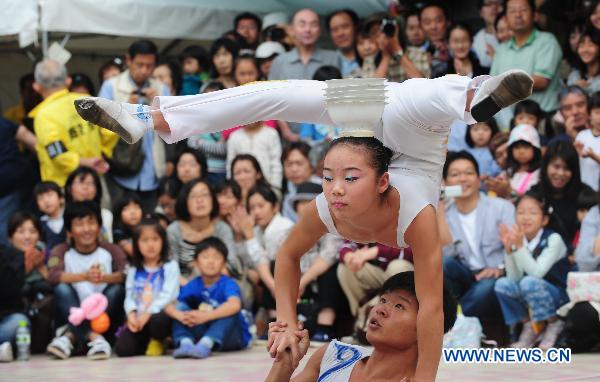 Chinese acrobats perform on the street in the Setagaya prefecture of Tokyo, capital of Japan. Oct. 17, 2010. 