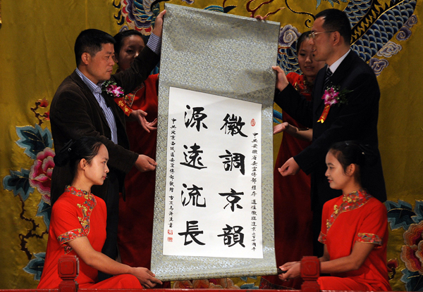 In the picture, representatives from Beijing and Anhui cultural institutions exchange gifts on October 17, 2010. [Xinhua photo]