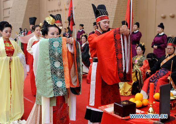 A couple attend a traditional Chinese memorial ceremony to the ancestor during a Chinese wedding in Xi'an, capital of northwest China's Shaanxi Province, Oct. 16, 2010. 