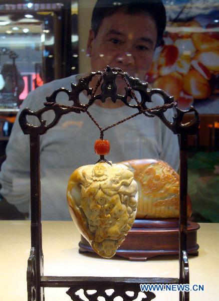 A visitor looks at a jade sculpture on an exhibition in Suzhou, east China's Jiangsu Province, Oct. 17, 2010. More than 300 jade sculpture works made by Su Ran, an artist of jade sculptures, were seen on a 10-day jade sculpture exhibition kicked off on Saturday. 