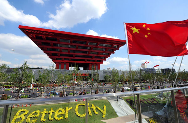 The national flag of the People's Republic of China floats in front of the China Pavilion as the National Pavilion Day for China opens on Oct 1, 2010, which is also the 61st anniversary of the founding of the PRC. [Xinhua] 