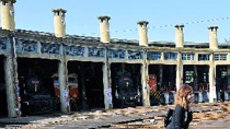 A girl poses for a souvenir photo in front of a sector-shaped locomotive garage in Changhua, southeast China's Taiwan, Oct. 18, 2010.