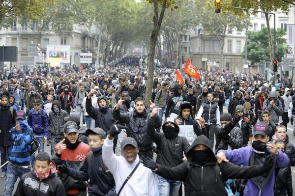 French students shout slogans during a demonstration over pension reforms with private and public sector workers in Lyon October 18, 2010. [Xinhua]