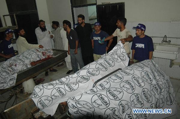 People gather around the dead bodies at a hospital in southern Pakistan's Karachi on Oct. 19, 2010. At least 17 people were killed in target killing that took place Tuesday evening in Pakistan's largest industrial city of Karachi, local media reported.[Toheed/Xinhua]