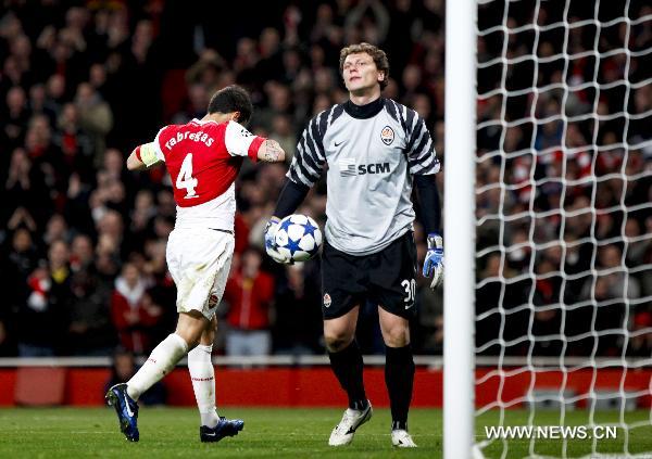 Arsenal's Cesc Fabregas (L) walks past Shakhtar Donetsk's goalkeeper Andriy Pyatov after his scored penalty kick during a group H match against Shakhtar Donetsk at the 2010-2011 UEFA Champions League at the Emirates Stadium in London, England, Oct. 19, 2010. Arsenal won 5-1. (Xinhua/Tang Shi)