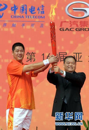 Huang Yebin (right), Secretary of the Huizhou Municipal Committee of the Communist Party of China, hands the torch to the first torchbearer Han Chaoming, a former Asian champion sprinter. 