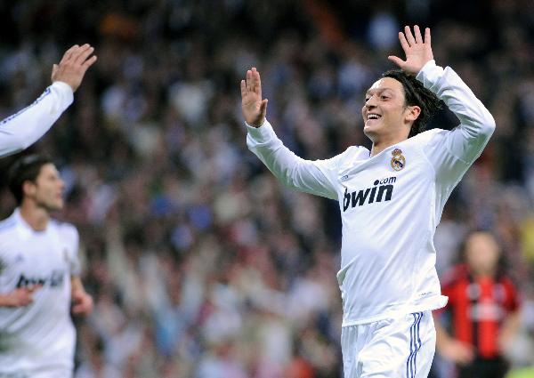 Ozil(R) of Real Madrid celebrates his goal during the 2010/2011 UEFA Champions League Group G soccer match against AC Milan at Santiago Bernabeu stadium in Madrid, capital of Spain, Oct.19, 2010. Real Madrid won 2-0. (Xinhua/Chen Haitong)