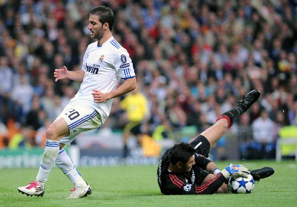 Higuain (L) of Real Madrid is blocked by the goalkeeper Marco Amelia of AC Milan during their 2010/2011 UEFA Champions League Group G soccer match at Santiago Bernabeu stadium in Madrid, capital of Spain, Oct.19, 2010. Real Madrid won 2-0. (Xinhua/Chen Haitong)