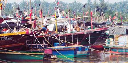Fishermen secure their boats at a port in Qionghai, Hainan province, on Tuesday. [China Daily] 