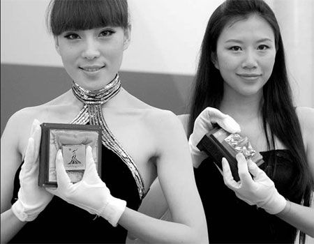 Models in Beijing present franchised gold souvenirs for the Guangzhou Asian Games. (Yuan Zhou/For China Daily)  