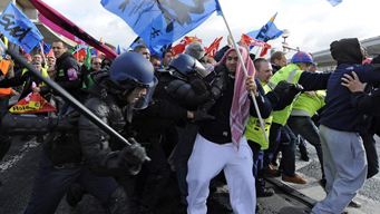 French striking workers face the police as they block the Charles-de-Gaulle airport in Roissy near Paris Oct 20, 2010.