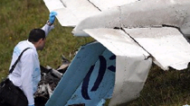 A forensic personnel checks the scene after a small plane crashed in San Antonio de Prado near Medellin, Colombia, Oct. 20, 2010.