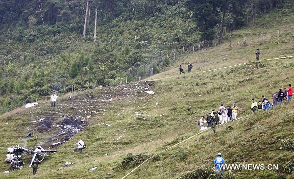 Police and forensic personnel work at the scene after a small plane crashed in San Antonio de Prado near Medellin, Colombia, Oct. 20, 2010. (Xinhua/Valentina Solano)