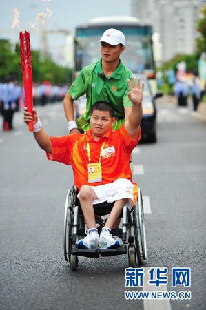 Wu Maoshun holds the torch in his wheelchair.