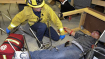 A rescue worker helps an 'injured' student during a quake drill in Los Angeles, California, the United States, Oct. 21, 2010.