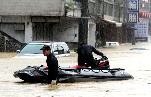 Rescuers work in a flooded street in Yilan county of Taiwan, Oct 21, 2010. Yilan county suffered from storm-triggered flood as Typhoon Megi approached the island on Thursday.