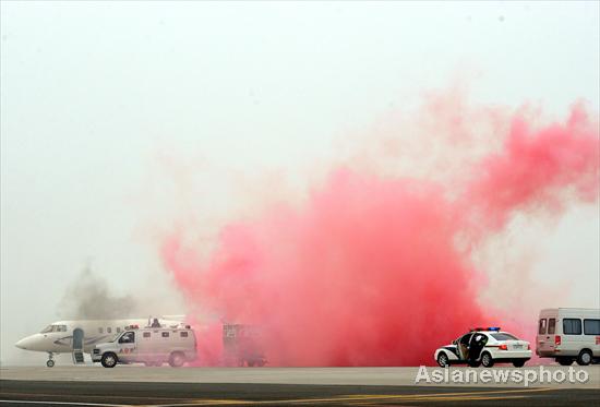 Red smoke grenade is deployed during an anti-hijack drill held at Beijing Capital International Airport, Oct 22, 2010. To deal with various potential attacks by domestic or international terrorists, the airport is working to improve its anti-hijack system with coordinated response strategies and acts of rescue. [chinadaily.com.cn] 