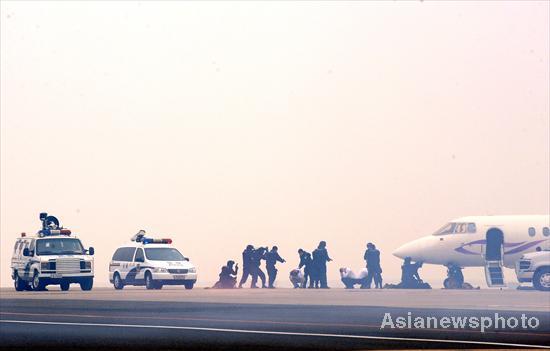 Armed policemen conduct an anti-hijack drill at Beijing Capital International Airport, Oct 22, 2010.