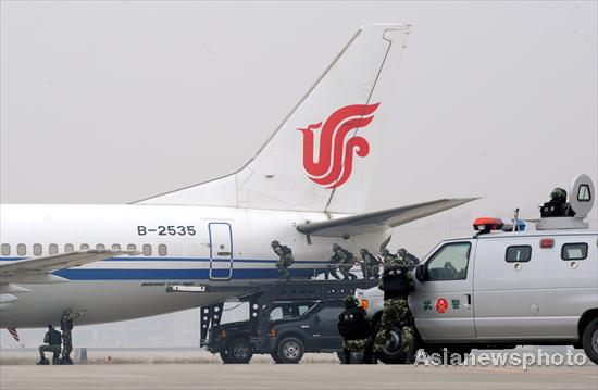 Armed policemen conduct an anti-hijack drill at Beijing Capital International Airport, Oct 22, 2010.