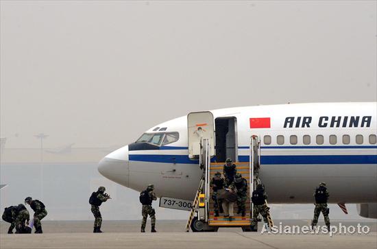 Armed policemen conduct an anti-hijack drill at Beijing Capital International Airport, Oct 22, 2010.